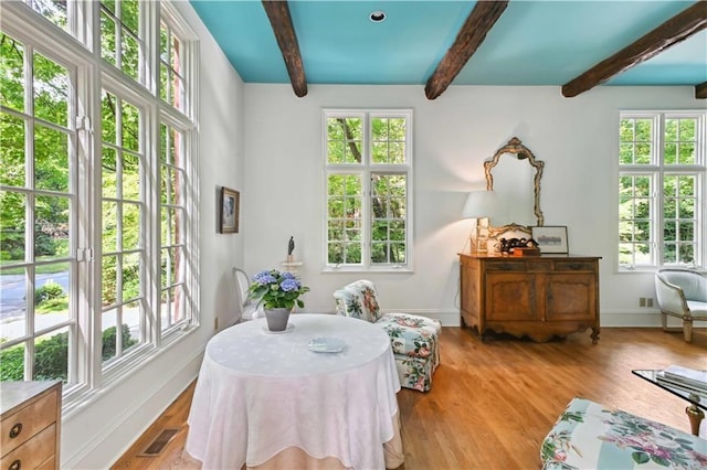 sitting room featuring wood finished floors, a healthy amount of sunlight, and visible vents