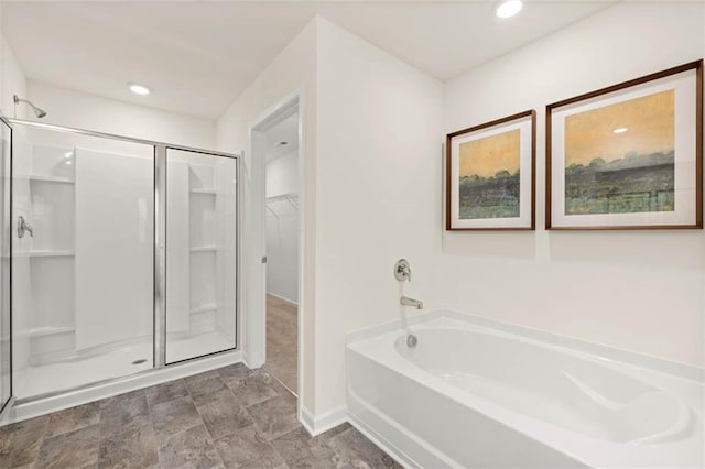 314 Sound Cir, Stockbridge, GA 30281 - bathroom featuring a stall shower, a bath, a walk in closet, baseboards, and recessed lighting