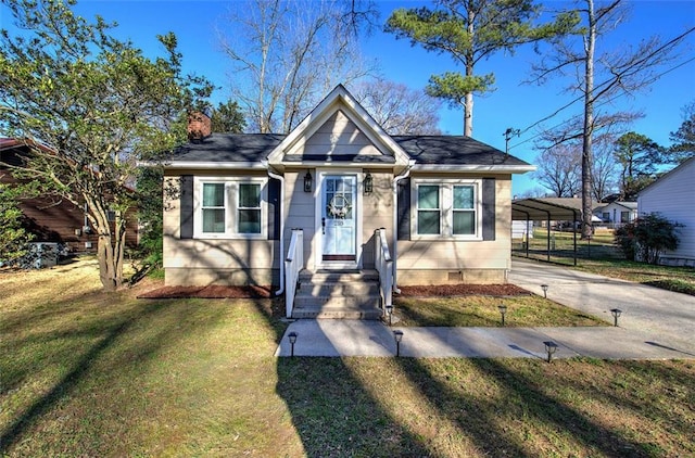 bungalow featuring a carport, a chimney, concrete driveway, and a front yard