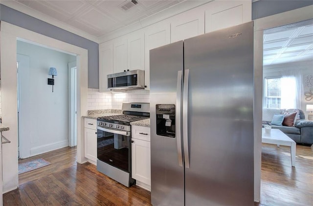 kitchen with visible vents, appliances with stainless steel finishes, decorative backsplash, dark wood finished floors, and an ornate ceiling