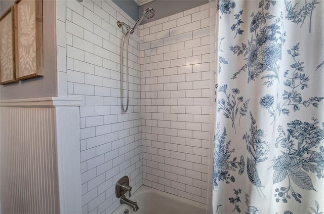 full bath featuring a wainscoted wall and shower / bathtub combination with curtain