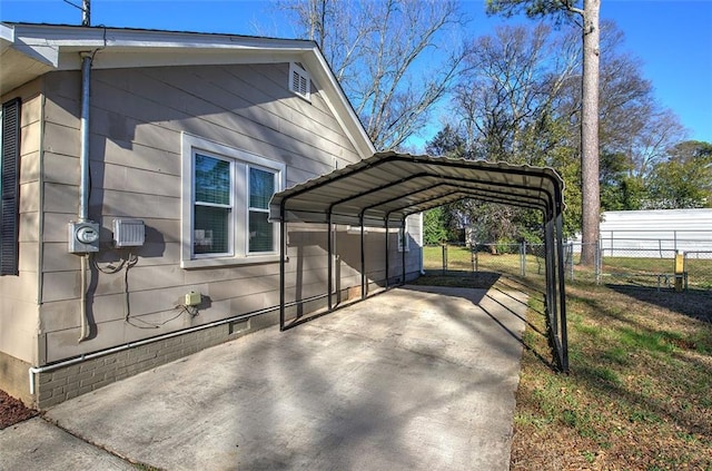 view of side of property with driveway, crawl space, fence, and a carport