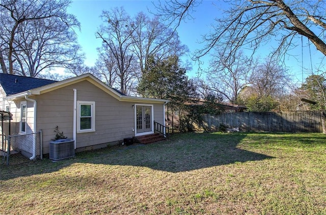 exterior space featuring a yard, french doors, central AC unit, and fence