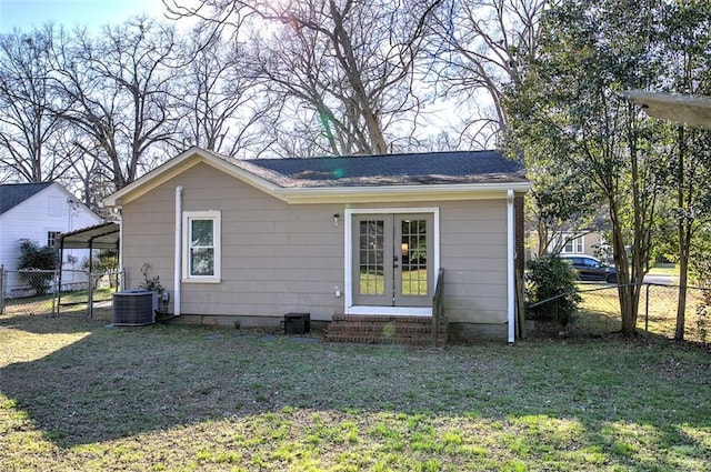 exterior space featuring entry steps, a yard, fence, french doors, and central air condition unit