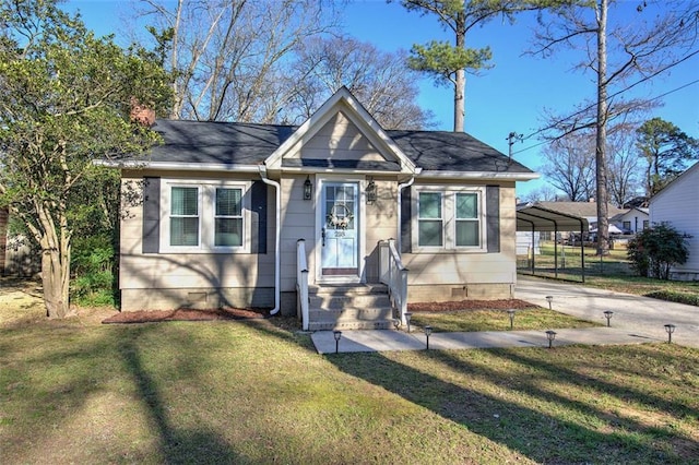 bungalow-style home with driveway, a shingled roof, a front lawn, and a detached carport