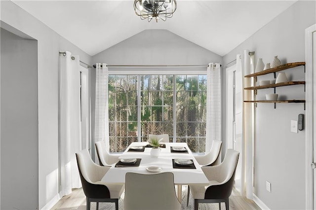 dining space featuring lofted ceiling and light hardwood / wood-style flooring