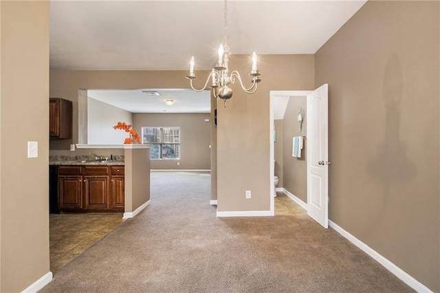 unfurnished dining area with light colored carpet, a sink, baseboards, and an inviting chandelier