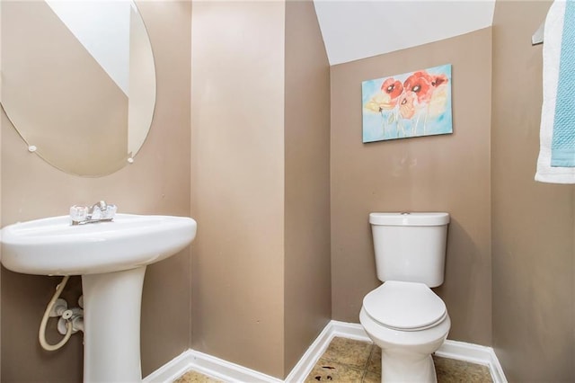 bathroom with toilet, baseboards, and tile patterned floors