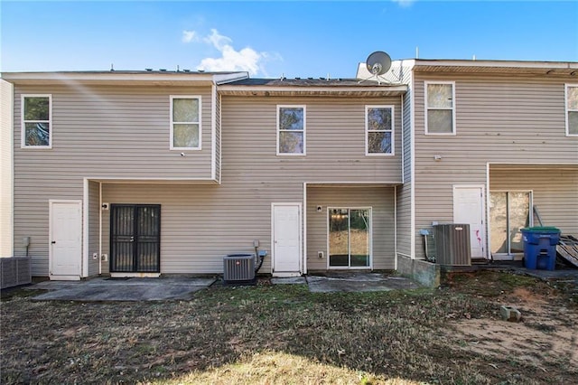 rear view of property featuring a patio, a yard, and central AC