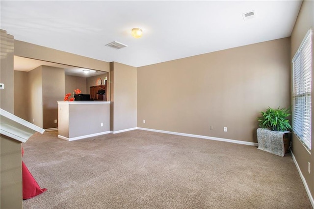 unfurnished living room with plenty of natural light, visible vents, and carpet flooring