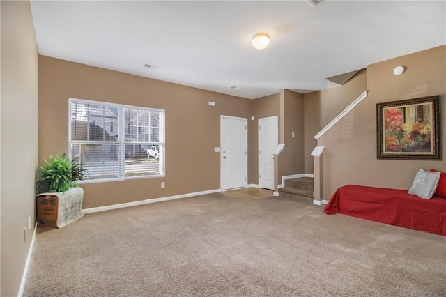 foyer entrance featuring visible vents, carpet flooring, stairway, and baseboards