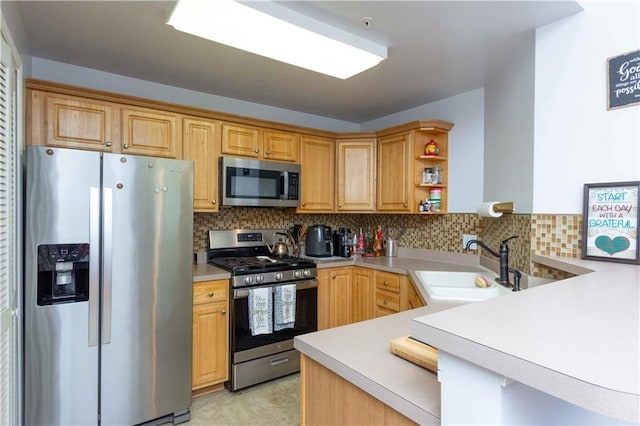 kitchen featuring kitchen peninsula, sink, decorative backsplash, and appliances with stainless steel finishes