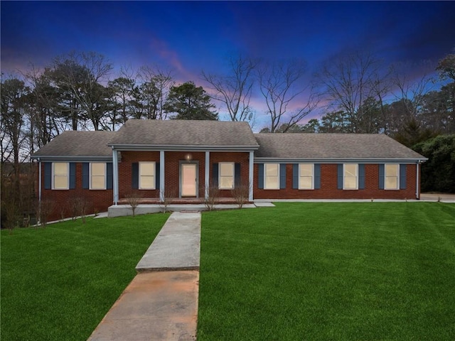 ranch-style house featuring a lawn and covered porch