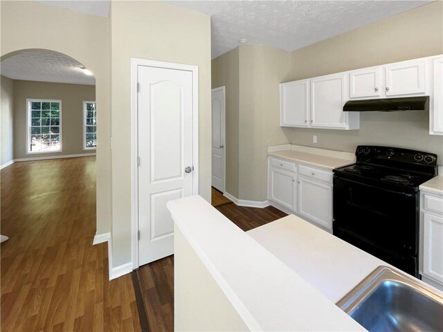 20 Pine Canyon Dr SW Unit 24, Atlanta, GA 30331 - kitchen featuring dark wood-style floors, light countertops, black electric range oven, under cabinet range hood, and arched walkways
