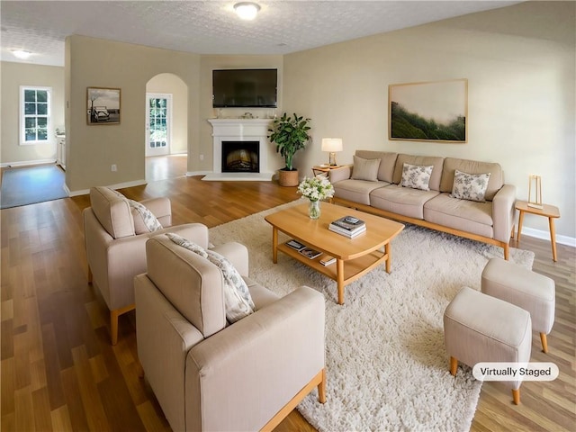 20 Pine Canyon Dr SW Unit 24, Atlanta, GA 30331 - living area featuring a fireplace, arched walkways, a textured ceiling, wood finished floors, and baseboards