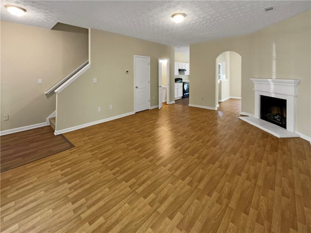 20 Pine Canyon Dr SW Unit 24, Atlanta, GA 30331 - unfurnished living room featuring arched walkways, light wood finished floors, and baseboards