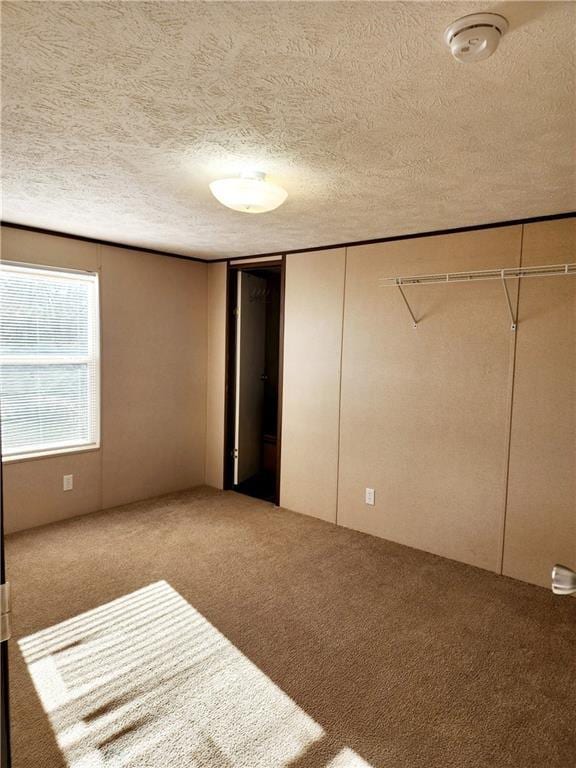 unfurnished bedroom with carpet flooring, a closet, and a textured ceiling