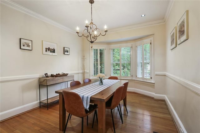 dining room featuring crown molding, dark hardwood / wood-style floors, and a chandelier