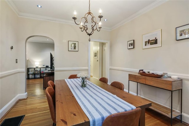 dining room with a chandelier, ornamental molding, and light hardwood / wood-style floors