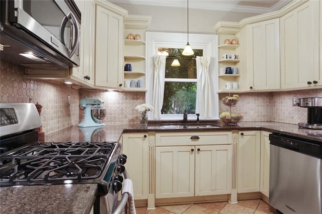 kitchen with appliances with stainless steel finishes, decorative light fixtures, tasteful backsplash, and cream cabinetry