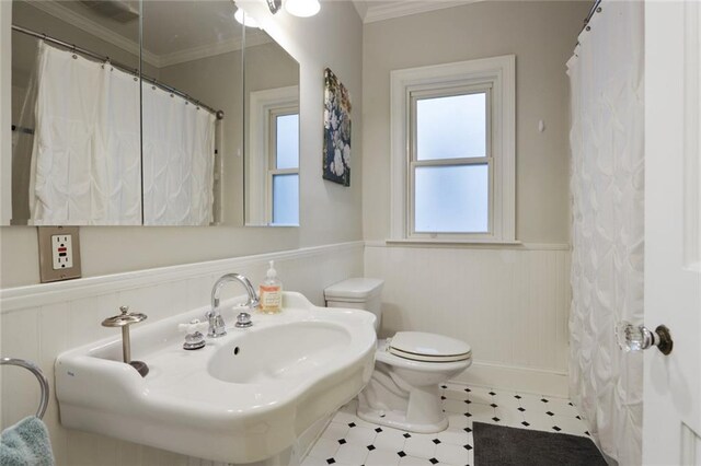 bathroom featuring crown molding, tile flooring, sink, and toilet