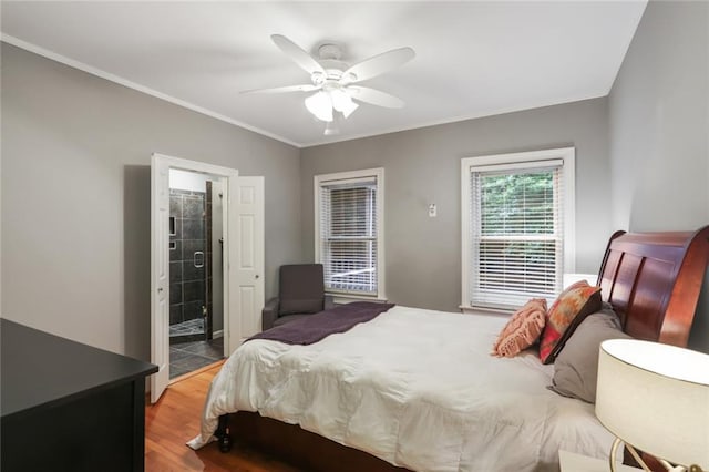 bedroom featuring ceiling fan, crown molding, ensuite bath, and light hardwood / wood-style floors