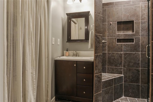 bathroom with a shower with door and vanity