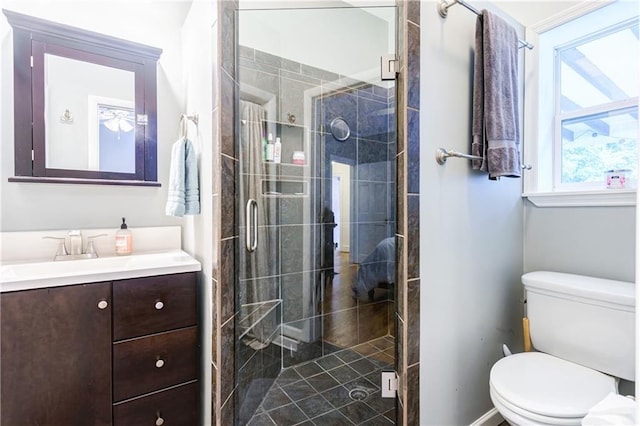 bathroom with toilet, a shower with shower door, and a healthy amount of sunlight