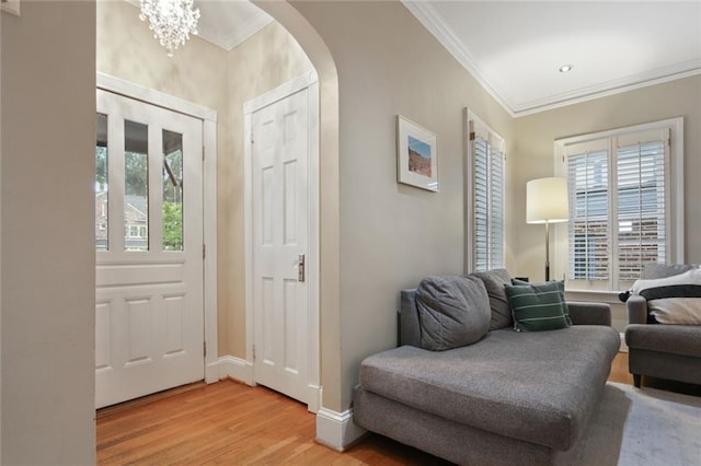 foyer featuring an inviting chandelier, light hardwood / wood-style floors, and ornamental molding