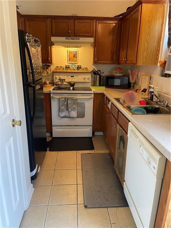 kitchen with light tile patterned flooring, black appliances, and sink