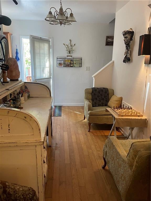 sitting room featuring a notable chandelier and light wood-type flooring