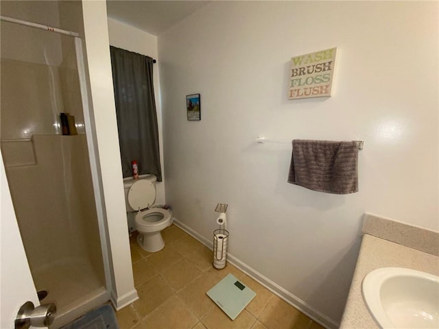 bathroom featuring toilet, tile patterned flooring, walk in shower, and vanity