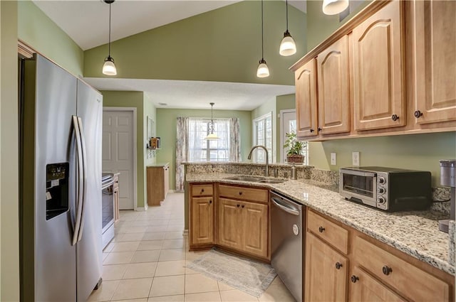 kitchen featuring light stone counters, light tile patterned flooring, stainless steel appliances, a peninsula, and a sink