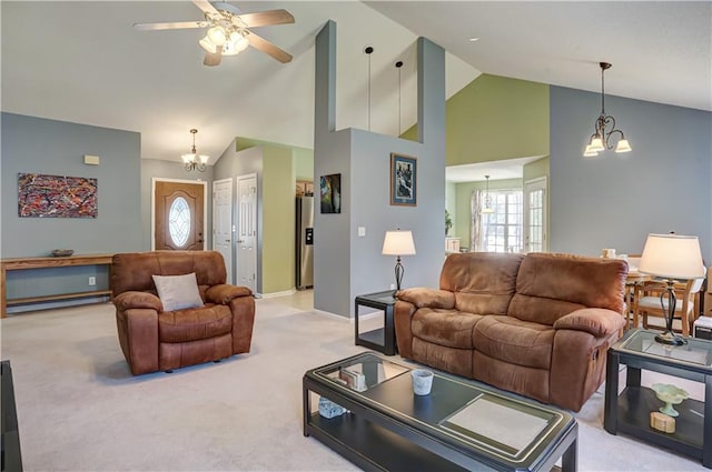 living area featuring high vaulted ceiling, light carpet, plenty of natural light, and ceiling fan with notable chandelier