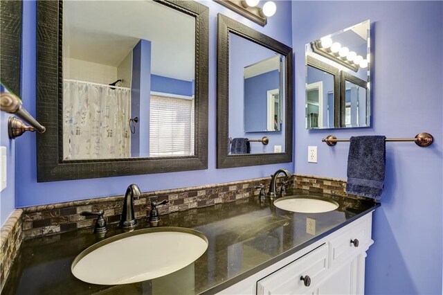 full bath featuring double vanity, a sink, and a shower with shower curtain