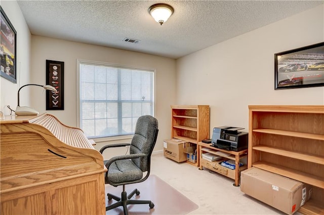 office space featuring carpet floors, visible vents, and a textured ceiling