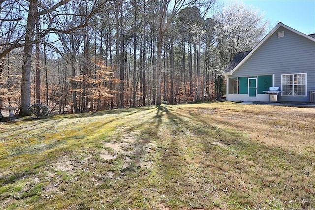 view of yard with a sunroom and central AC unit