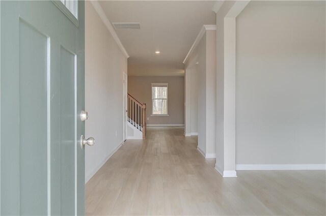 corridor featuring crown molding and light wood-type flooring