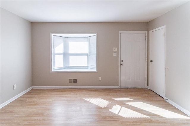 empty room with light hardwood / wood-style flooring