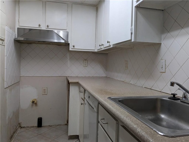 kitchen featuring under cabinet range hood, a sink, white cabinetry, white dishwasher, and light tile patterned floors