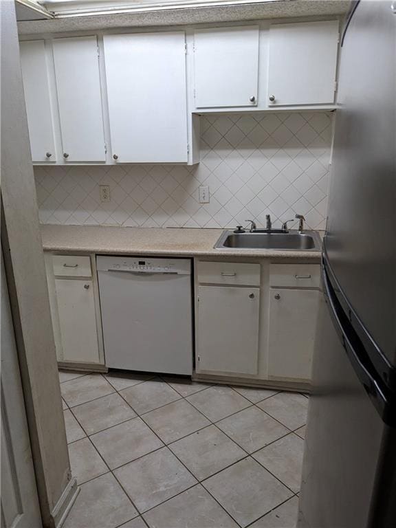 kitchen with a sink, white cabinetry, light tile patterned flooring, white dishwasher, and light countertops