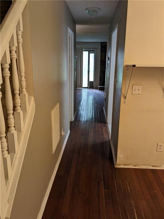 corridor featuring stairs, baseboards, visible vents, and dark wood-style flooring