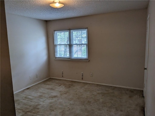 unfurnished room featuring a textured ceiling, baseboards, and carpet floors