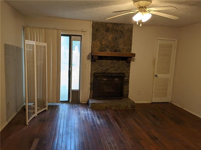 unfurnished living room with hardwood / wood-style floors, a ceiling fan, baseboards, a fireplace, and a textured ceiling