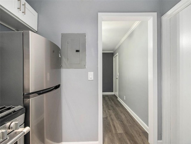 kitchen featuring electric panel, stainless steel fridge, ornamental molding, white cabinetry, and wood-type flooring