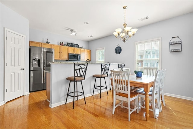 5989 Turfway Park Ct, Sugar Hill, GA 30518 - dining area featuring plenty of natural light, a chandelier, light wood-style flooring, and baseboards
