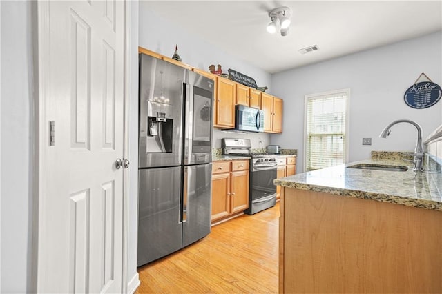 5989 Turfway Park Ct, Sugar Hill, GA 30518 - kitchen with appliances with stainless steel finishes, a sink, light wood-style flooring, and light stone counters
