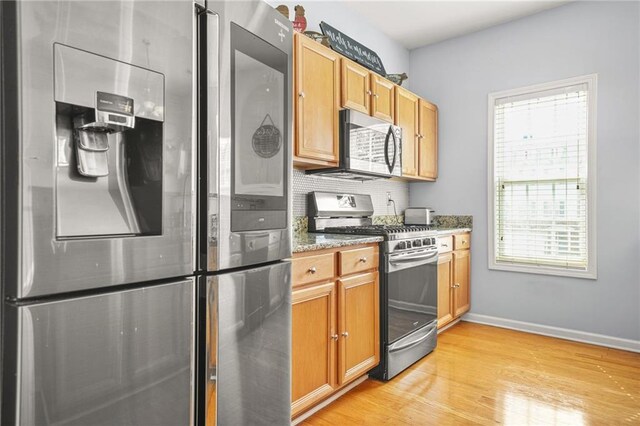 5989 Turfway Park Ct, Sugar Hill, GA 30518 - kitchen featuring appliances with stainless steel finishes, light wood-style floors, baseboards, light stone countertops, and decorative backsplash