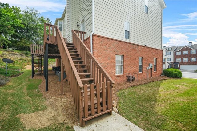 5989 Turfway Park Ct, Sugar Hill, GA 30518 - view of home's exterior featuring stairway, brick siding, a lawn, and a wooden deck