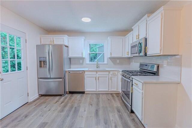 159 Aztec Way SE, Acworth, GA 30102 - kitchen featuring appliances with stainless steel finishes, a sink, white cabinets, and light wood-style floors